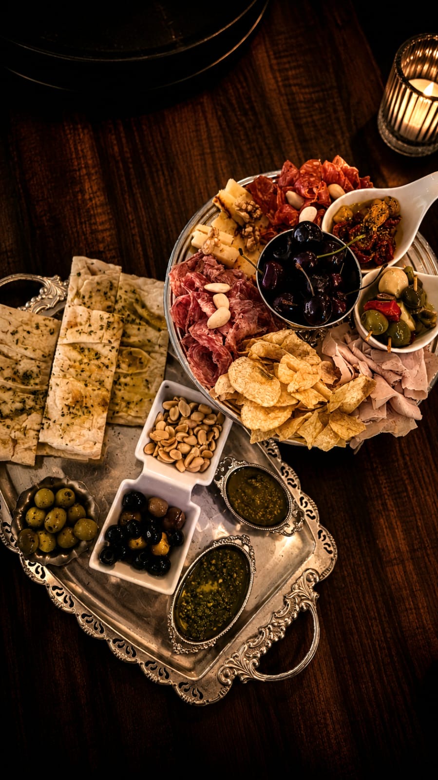 Tabla redonda con salami, jamón, quesos, cerezas, aceitunas y pestos artesanos