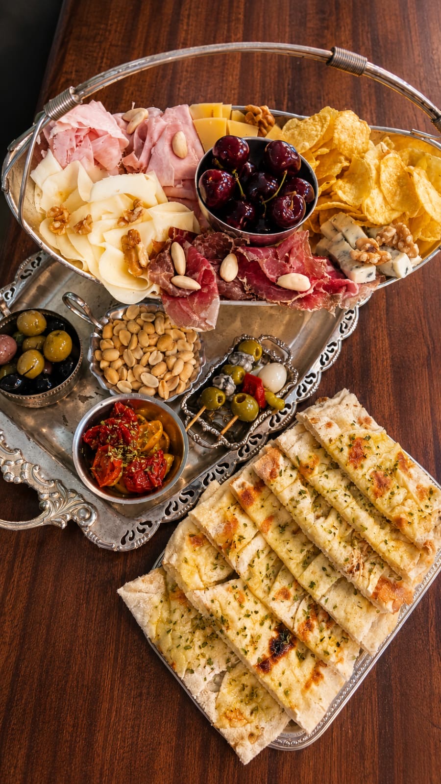 Cesta de embutidos con jamón, quesos, cerezas, frutos secos y focaccia recién horneada